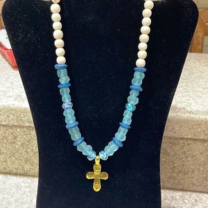Gorgeous glass, teal necklace with cross accents of blue and wooden beads up top